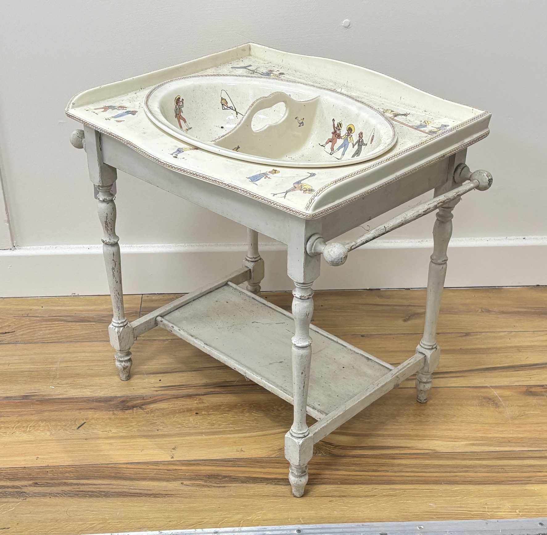 A French Sarreguemines pottery child's basin decorated with nursery scenes and matching wash stand, 51 x 37 x 48cm